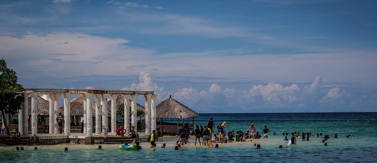 A long white sandbar at low tide on an island-hopping trip from Cebu