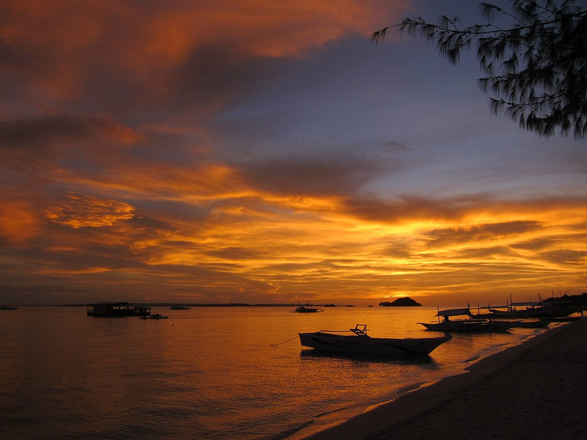 Bounty Beach on Malapascua Island, Cebu, with white sand and outrigger boats