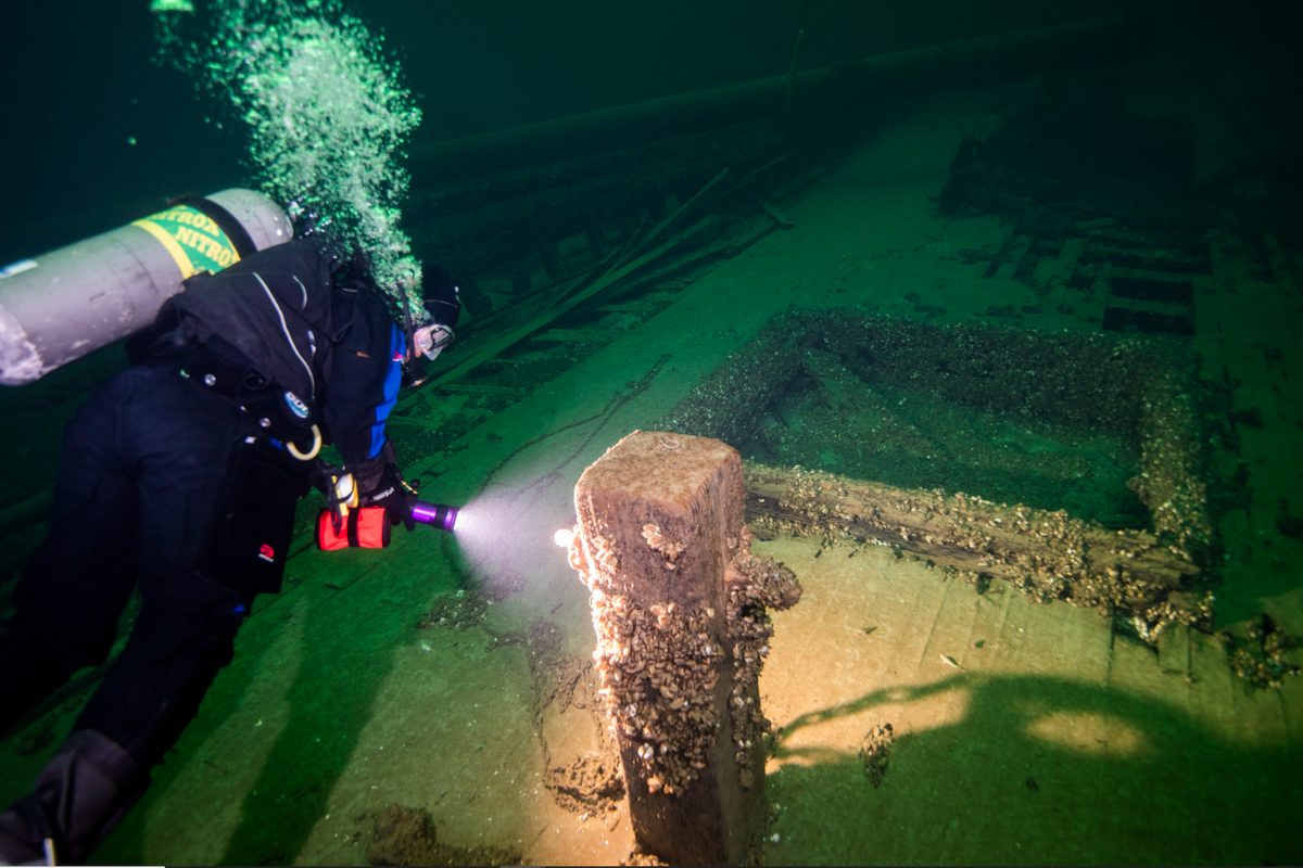 Coron wreck diving: a scuba diver explores a coral-encrusted shipwreck like the WWII wrecks of Coron Bay, Palawan