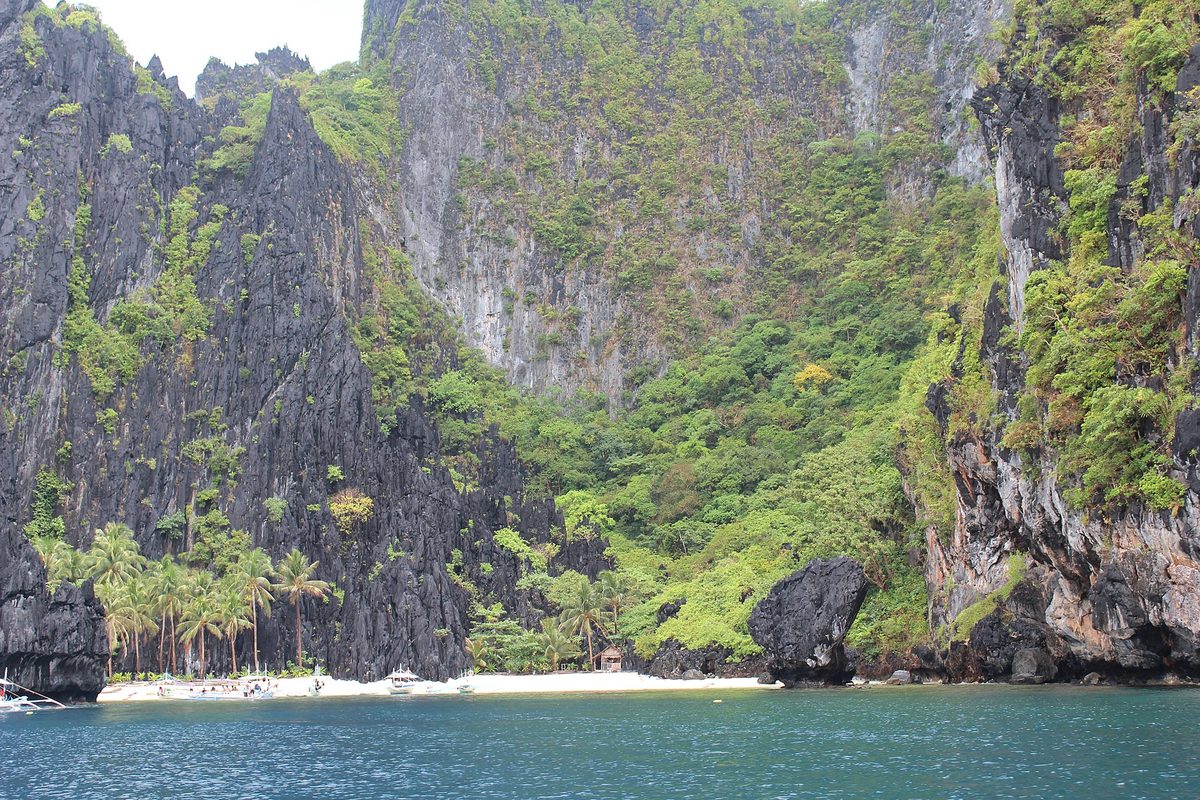 Hidden cove of Secret Beach reached through a gap in the cliffs on El Nido Tour C, Palawan
