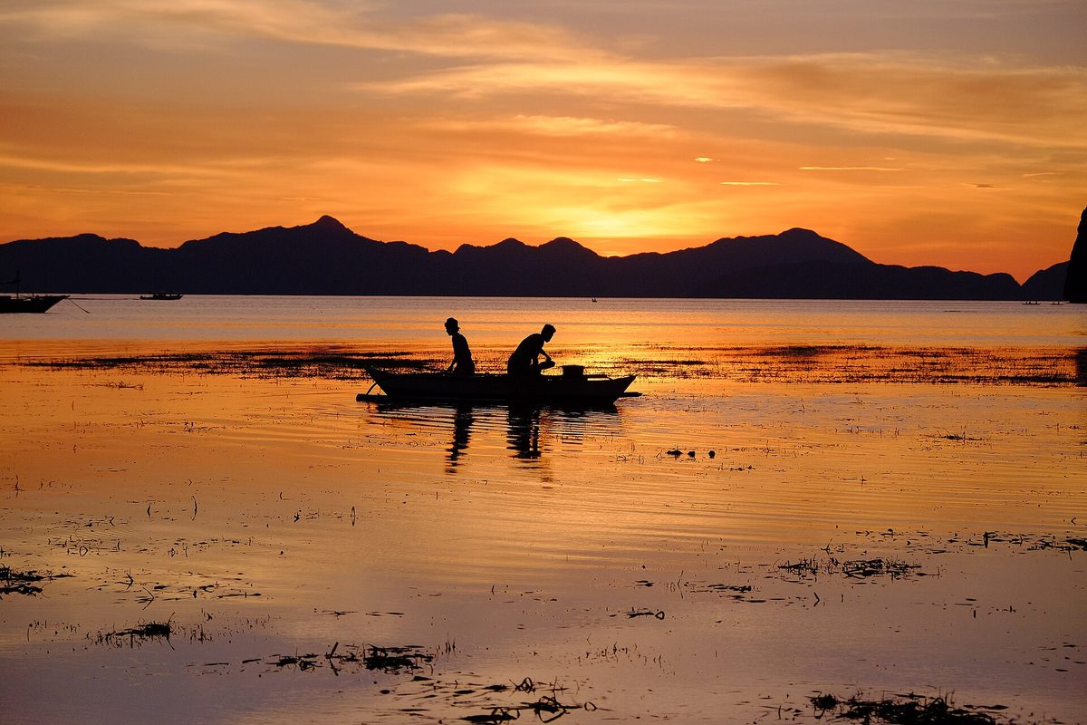 Sunset over the water from Las Cabanas Beach near Corong-Corong, El Nido
