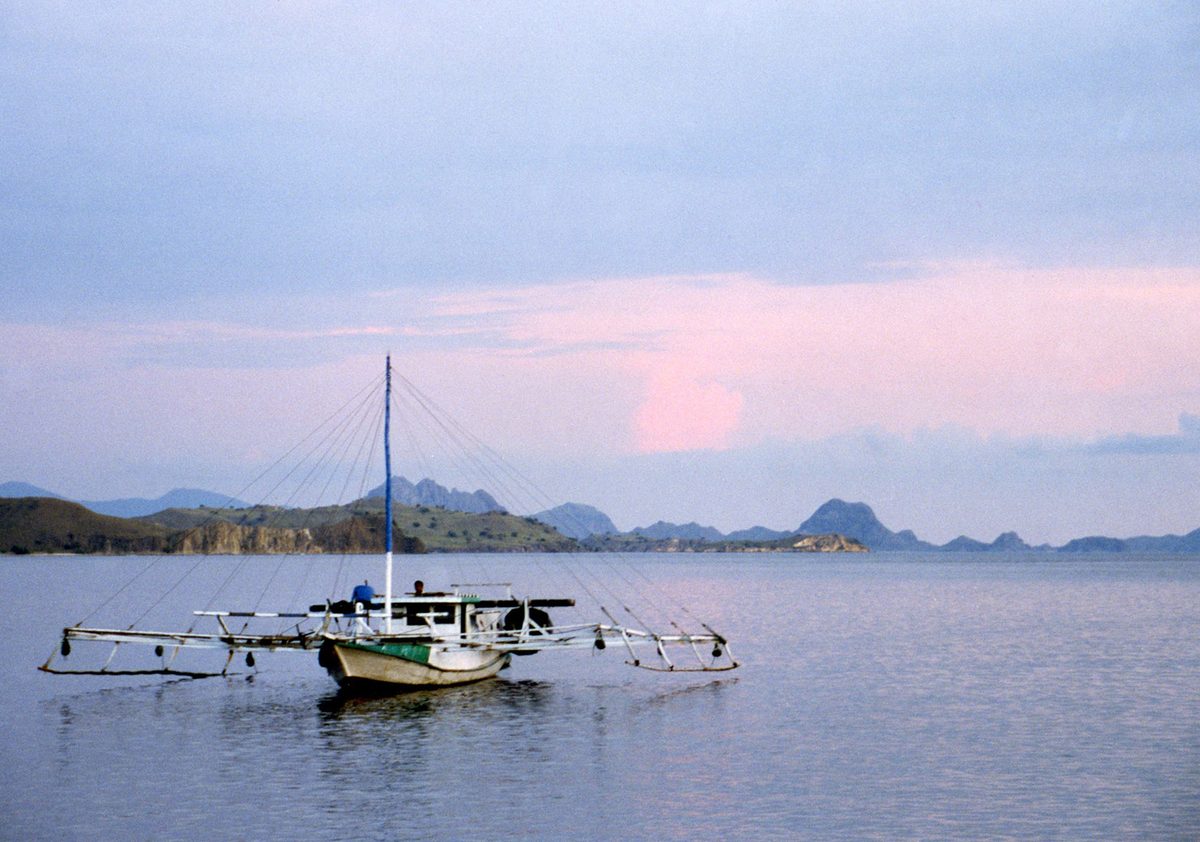 Traditional Filipino outrigger bangka boat on calm water in Palawan, Philippines, the kind used for expedition crossings