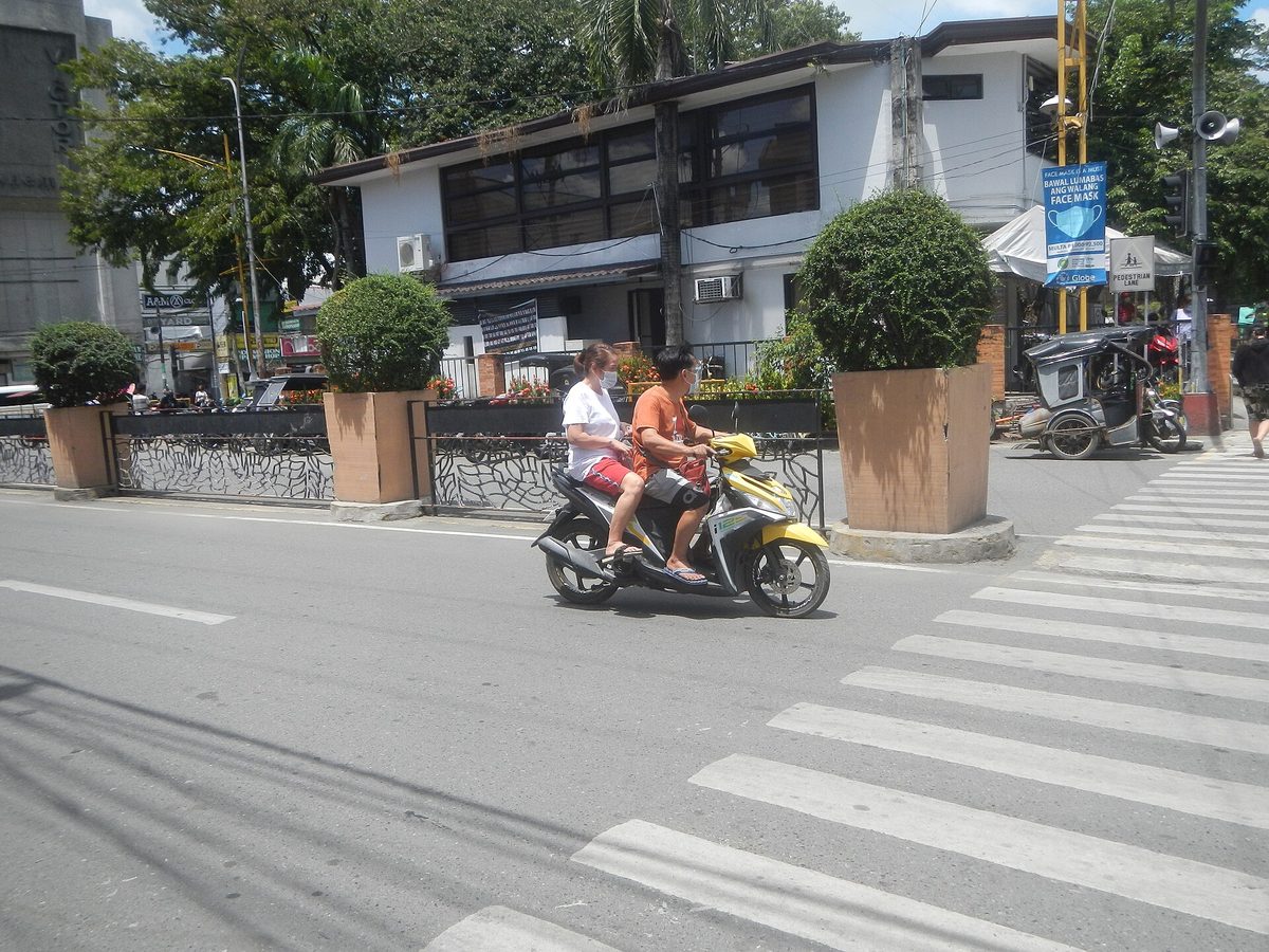 A scooter rider on a Philippines road, where most travel insurance only pays a claim if you hold a valid motorcycle licence