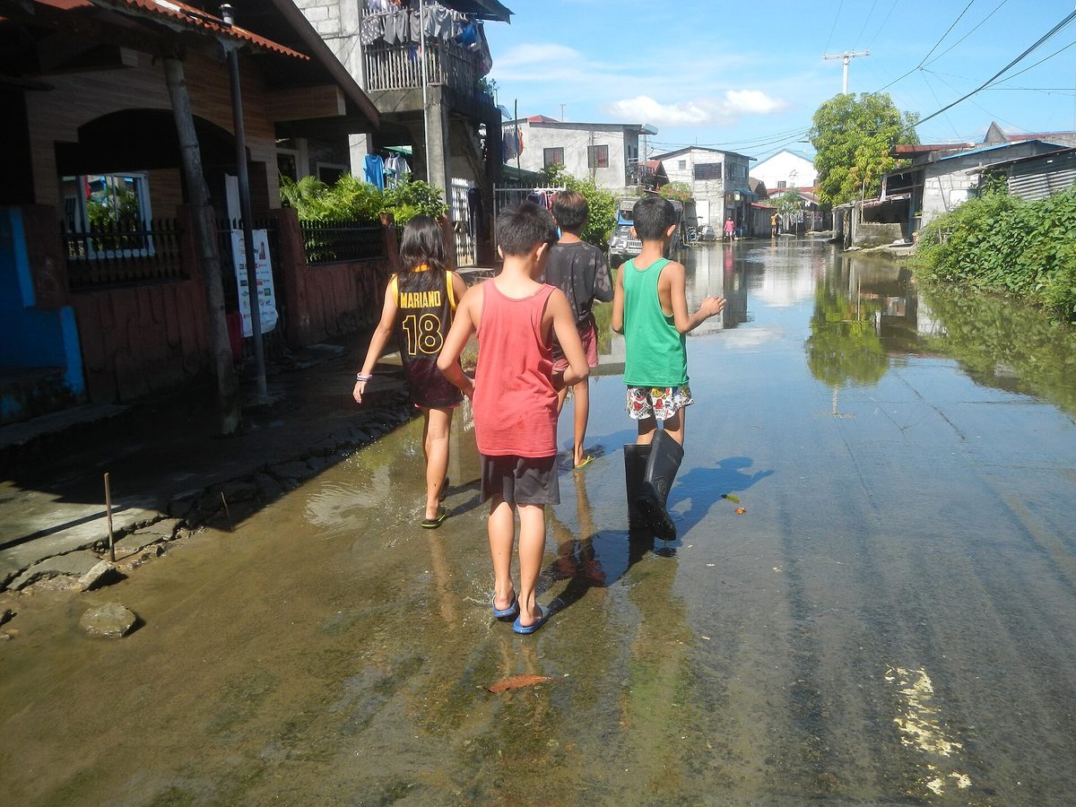 A flooded street during a Philippines typhoon, the kind of weather disruption that trip cancellation cover protects against