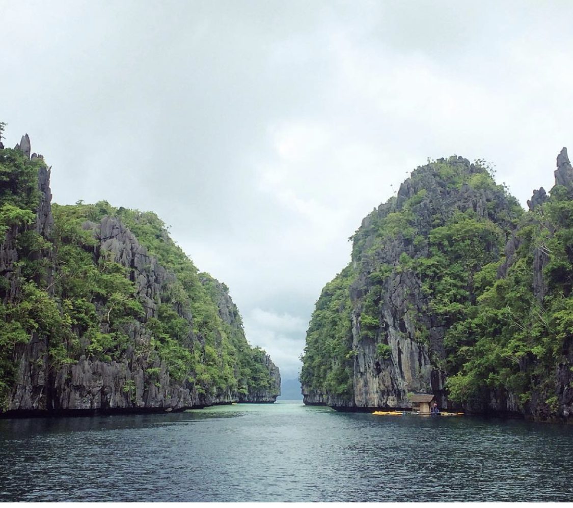 Turquoise water and towering limestone cliffs at a lagoon near El Nido, Palawan, the most famous island-hopping destination in the Philippines