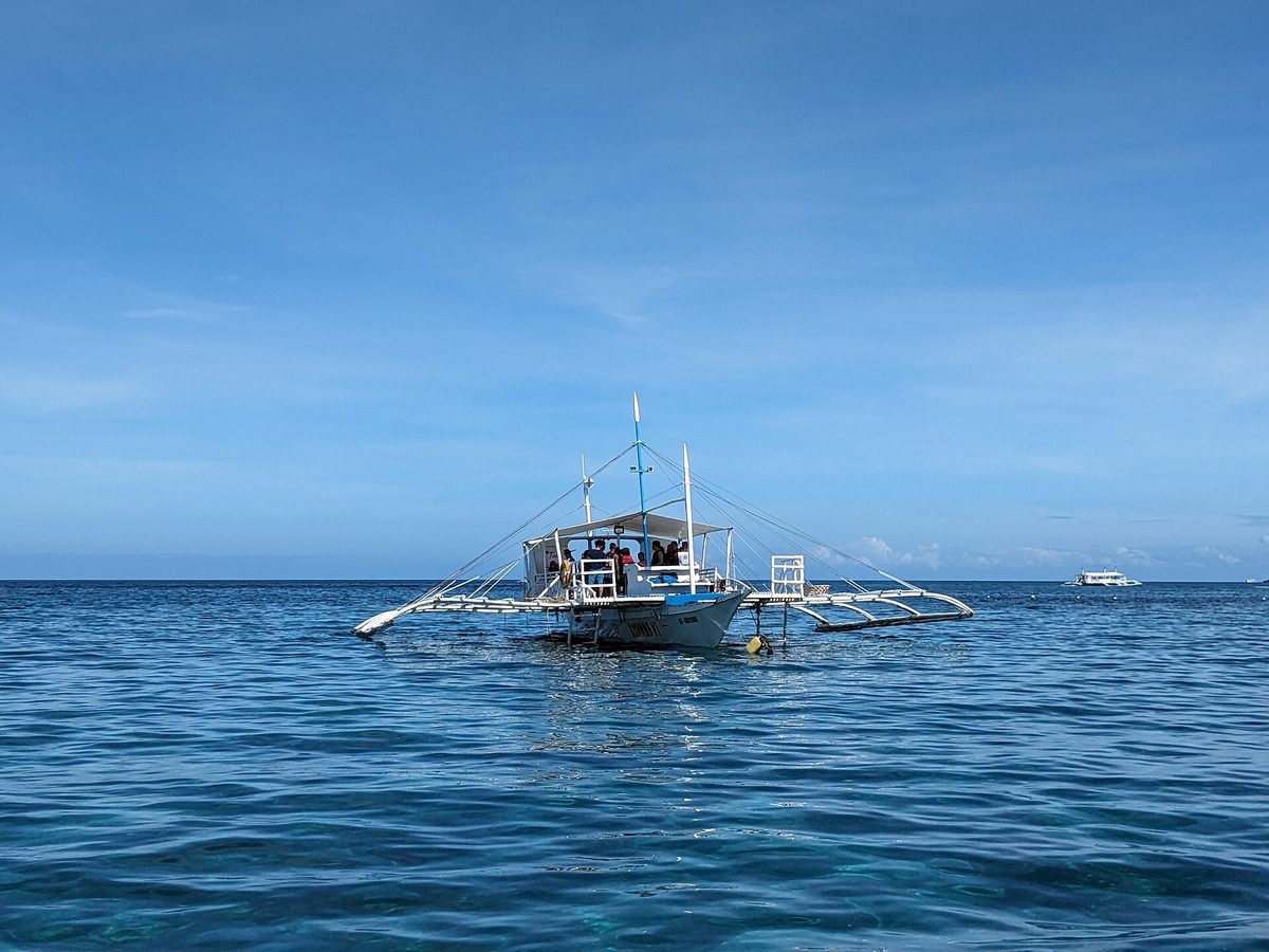 Sandy beach and outrigger boats at Malapascua Island, the dive base off northern Cebu