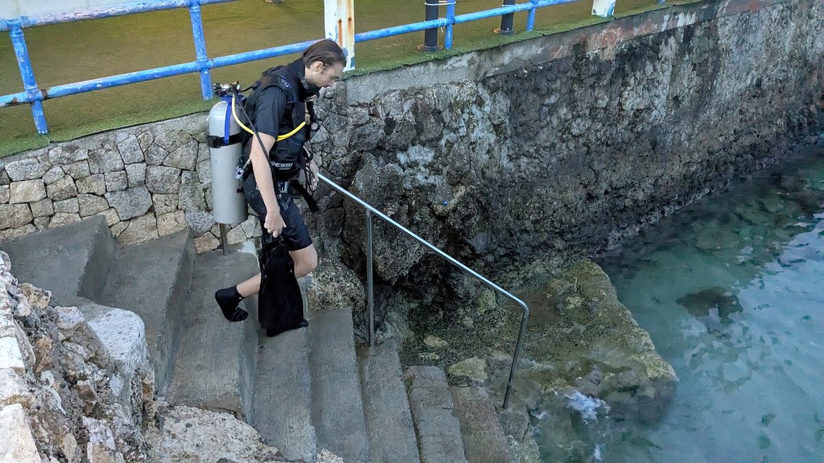 Scuba diver entering the water for a dive in the Philippines