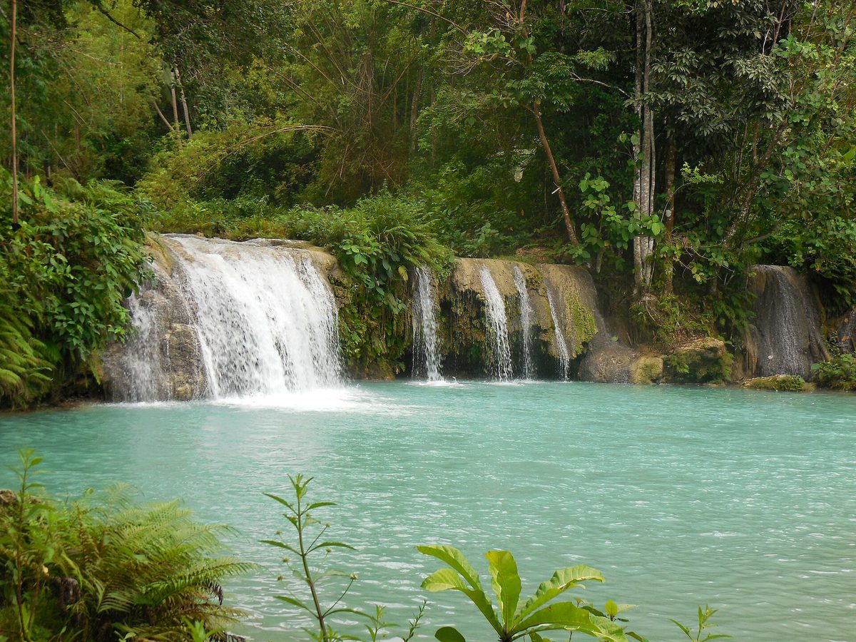 Turquoise tiered pools of Cambugahay Falls framed by jungle on Siquijor island