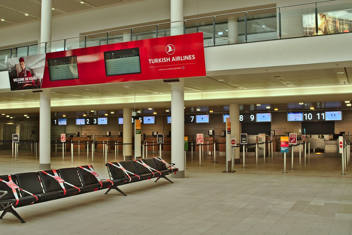 Travelers at an airline check-in counter, where agents typically ask for proof of onward travel before a flight to the Philippines