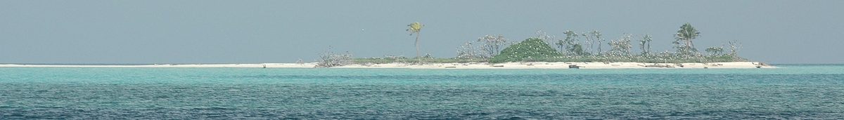 A low coral island and turquoise shallows at Tubbataha Reefs Natural Park in the Philippines, a marine protected area where reef-safe sunscreen is required