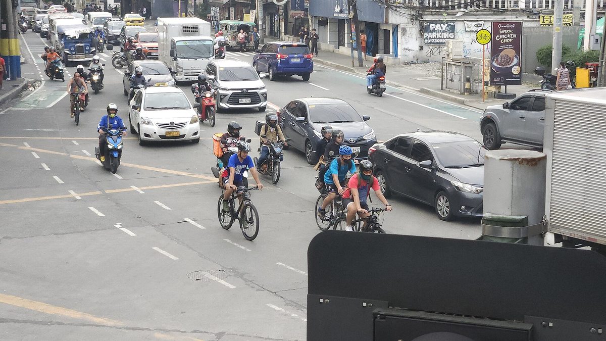 A white metered taxi in Manila traffic, where philippines tourist scams most often start with a broken-meter claim