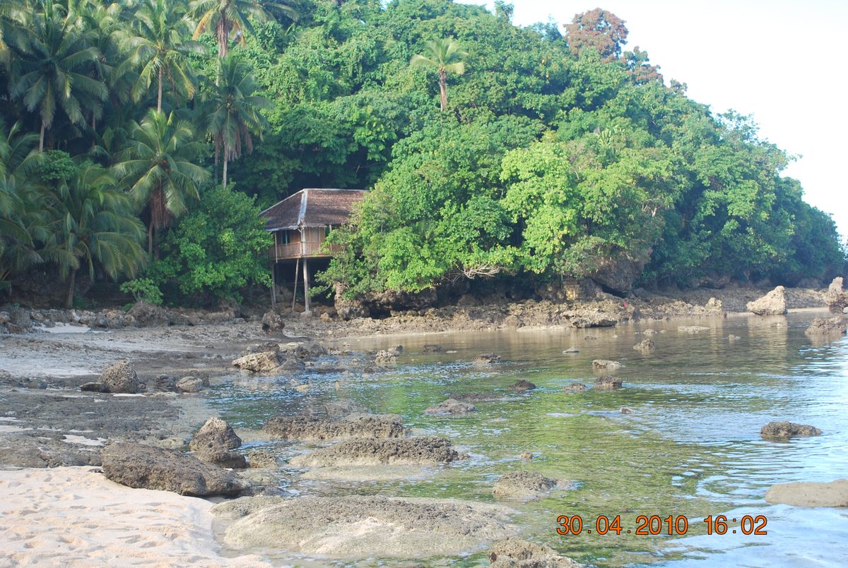 Magpupungko Rock Pools shoreline and stilt cottage at low tide on Siargao Island