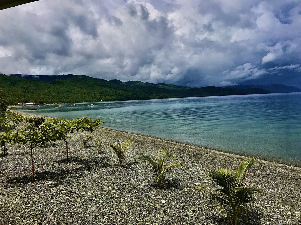 Dark storm clouds building over a tropical Philippine coastline before a rain squall